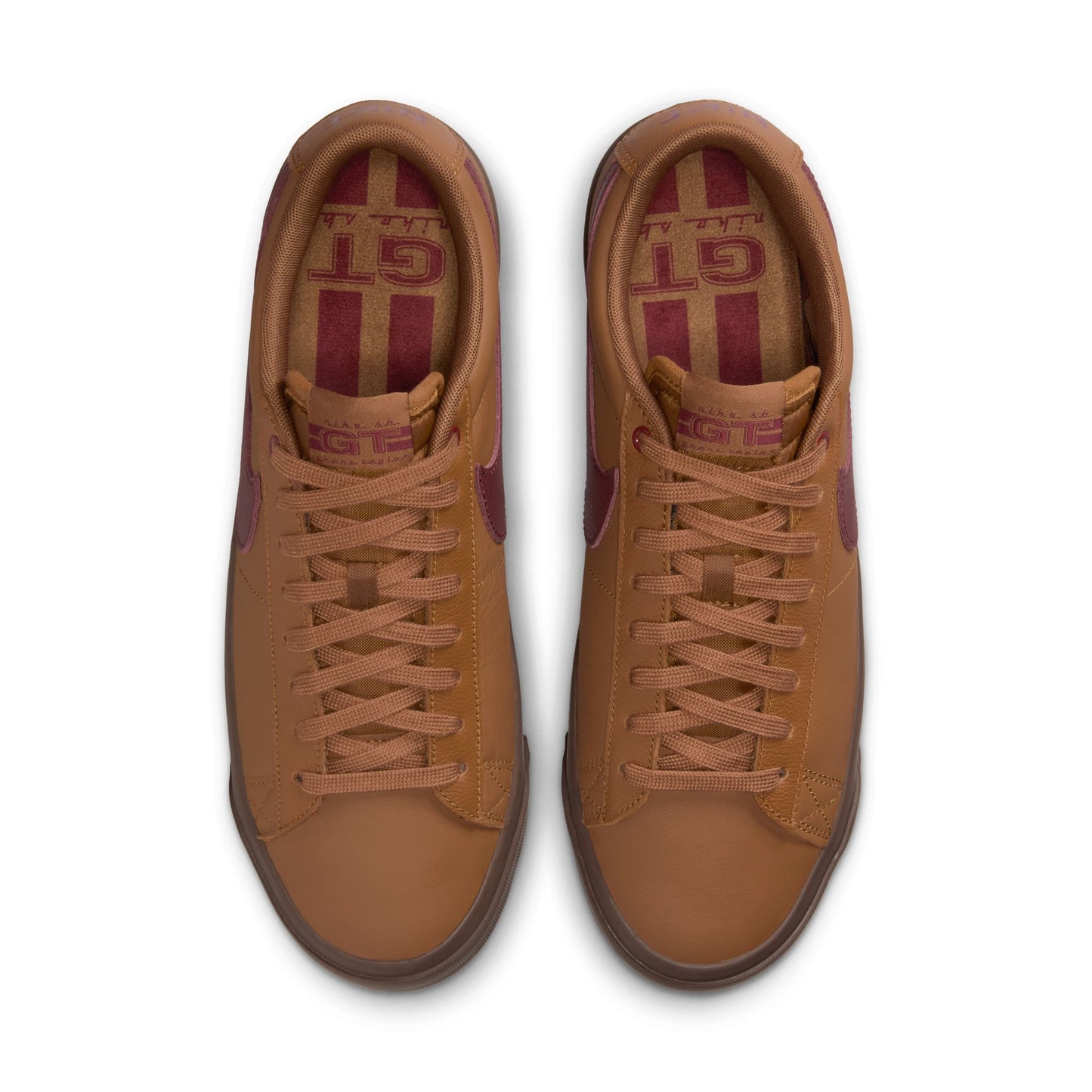 Pair of brown sneakers with red accents on a white background