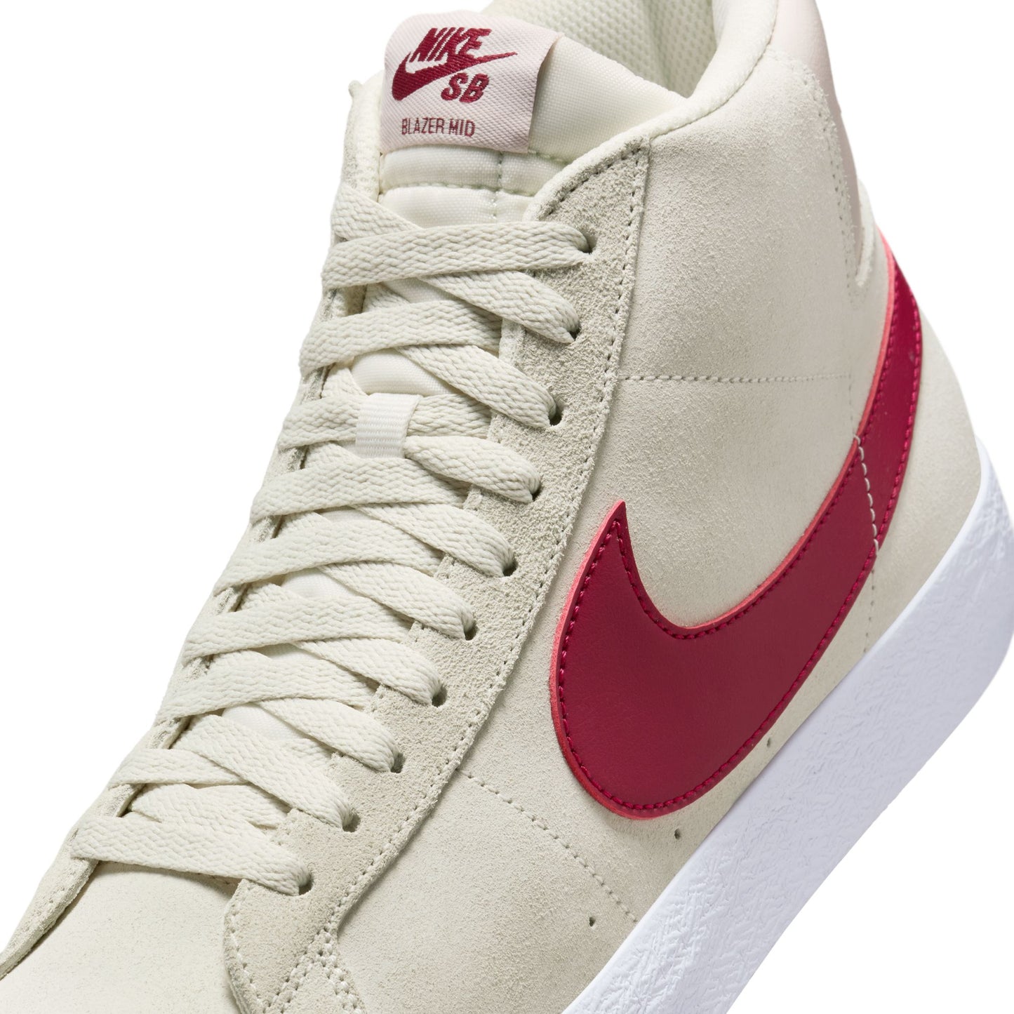 Beige sneaker with red swoosh logo on a white background
