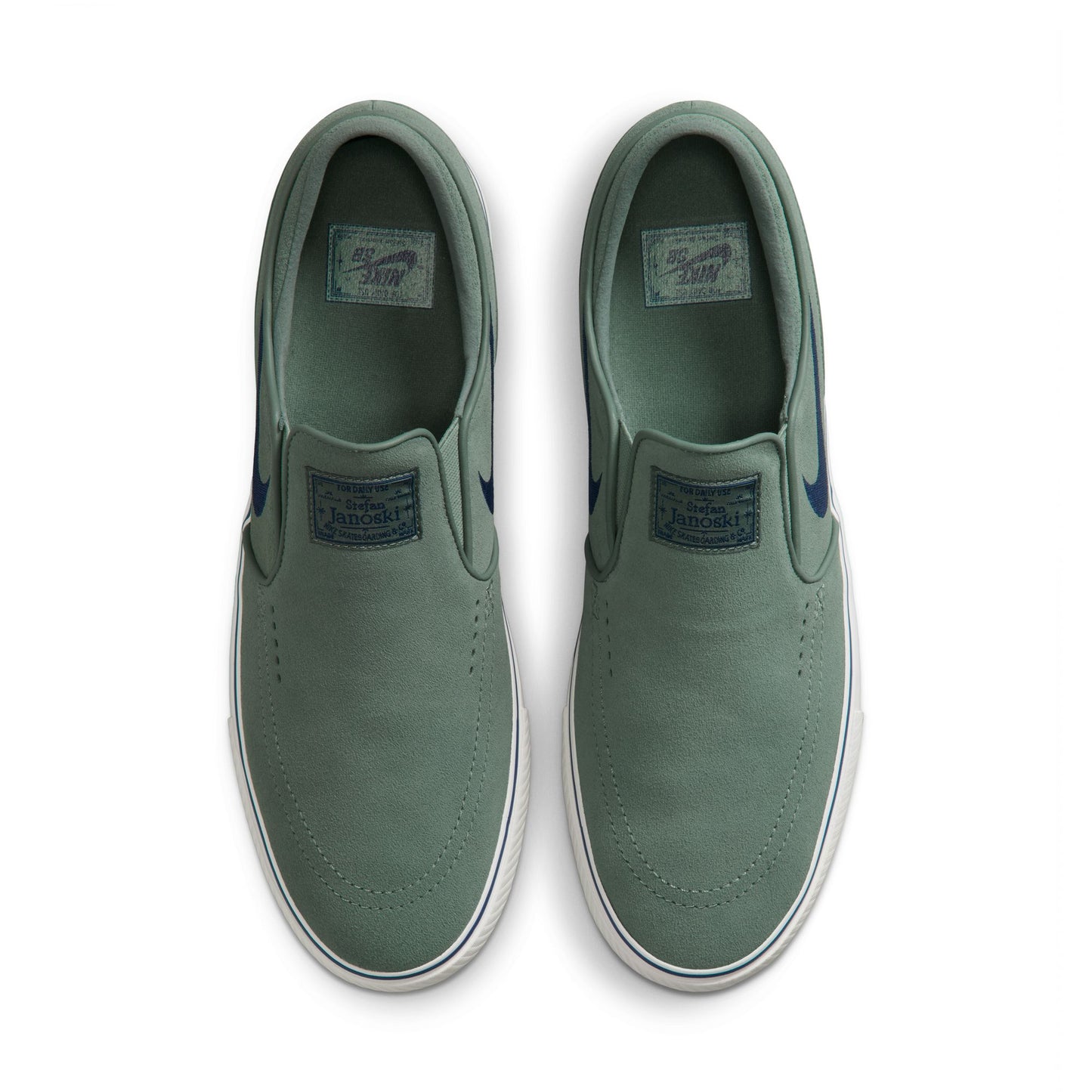 Pair of green slip-on shoes on a white background