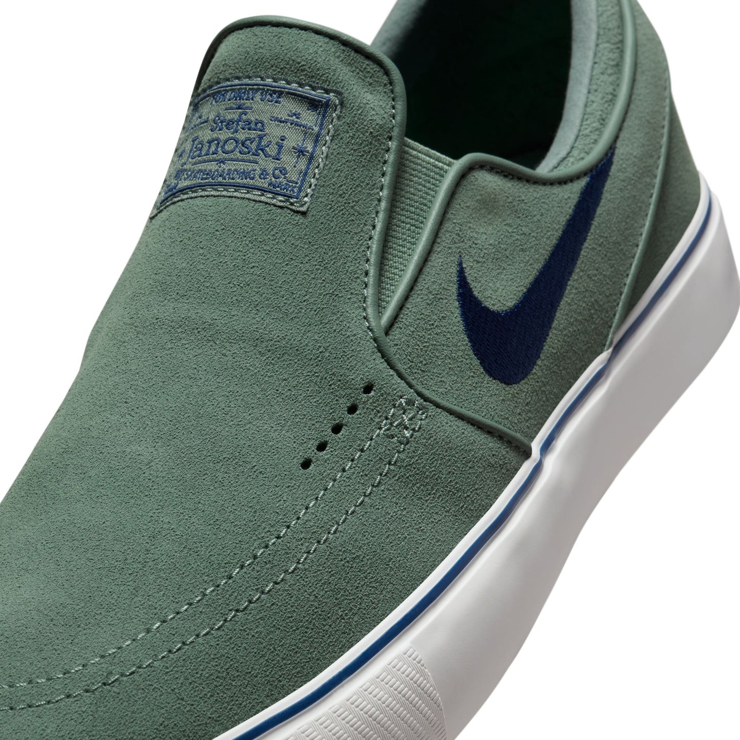 Green slip-on sneaker with a blue Nike logo on a white background