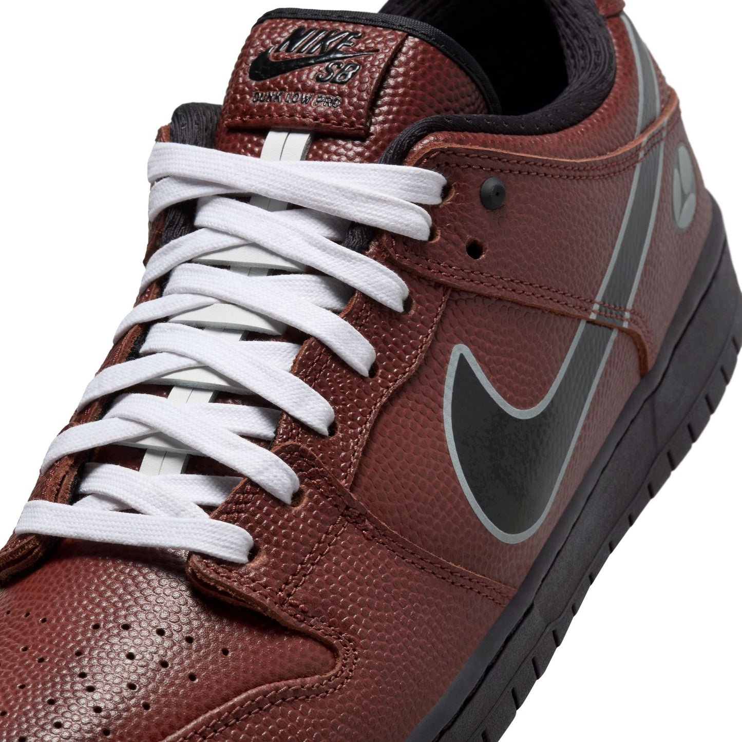 Brown sneaker with white laces and a black swoosh logo on a white background