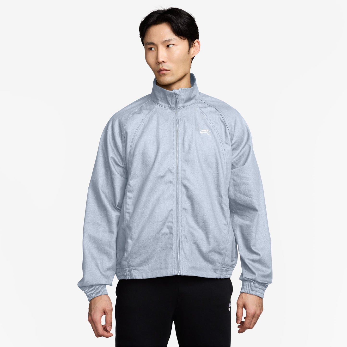 Person wearing a light blue jacket on a white background