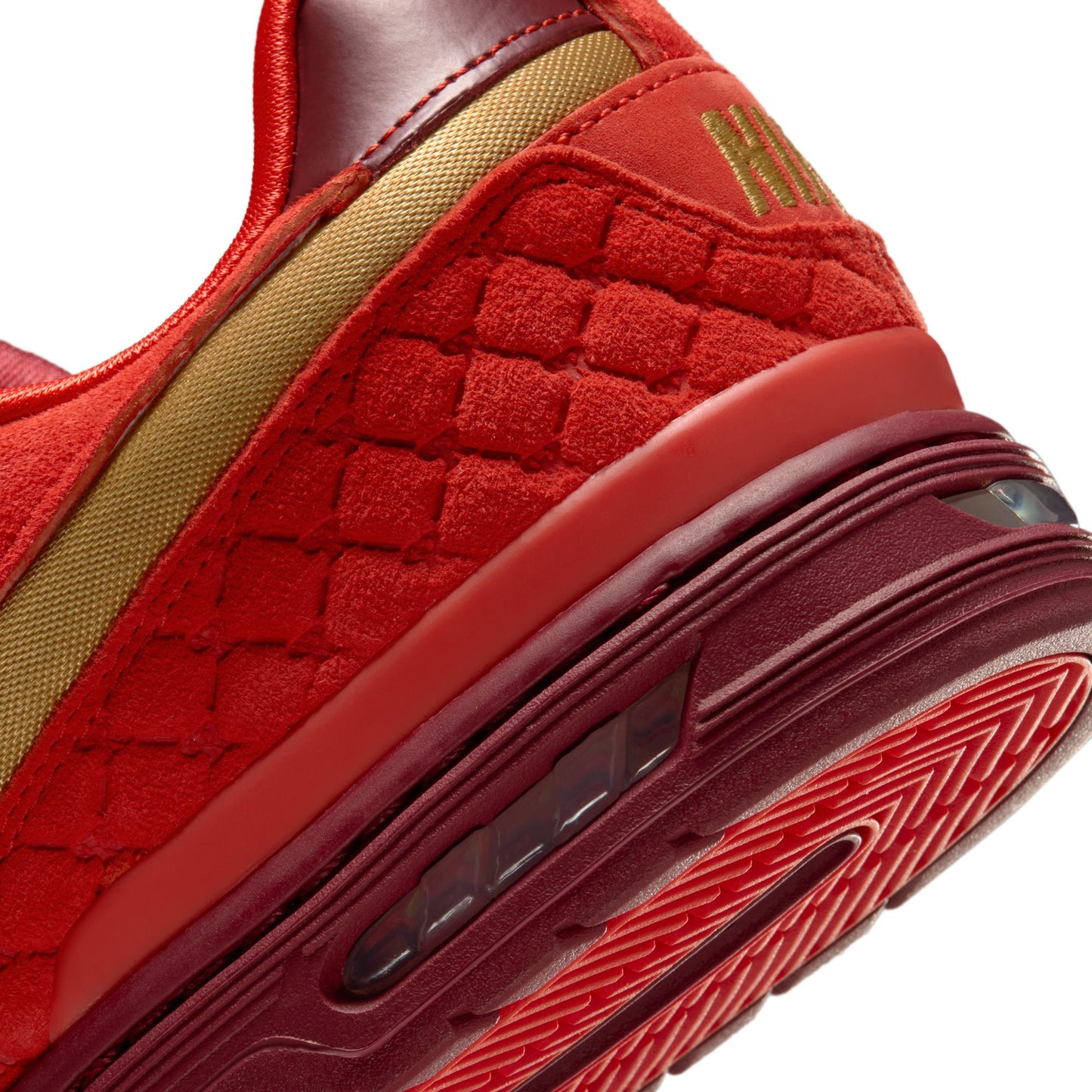 Close-up of a red sneaker with textured design and visible brand logo.