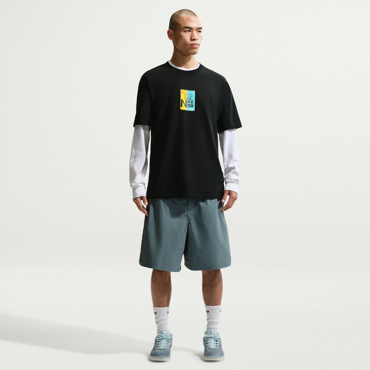 Man wearing a black t-shirt with a colorful graphic, on a white background.