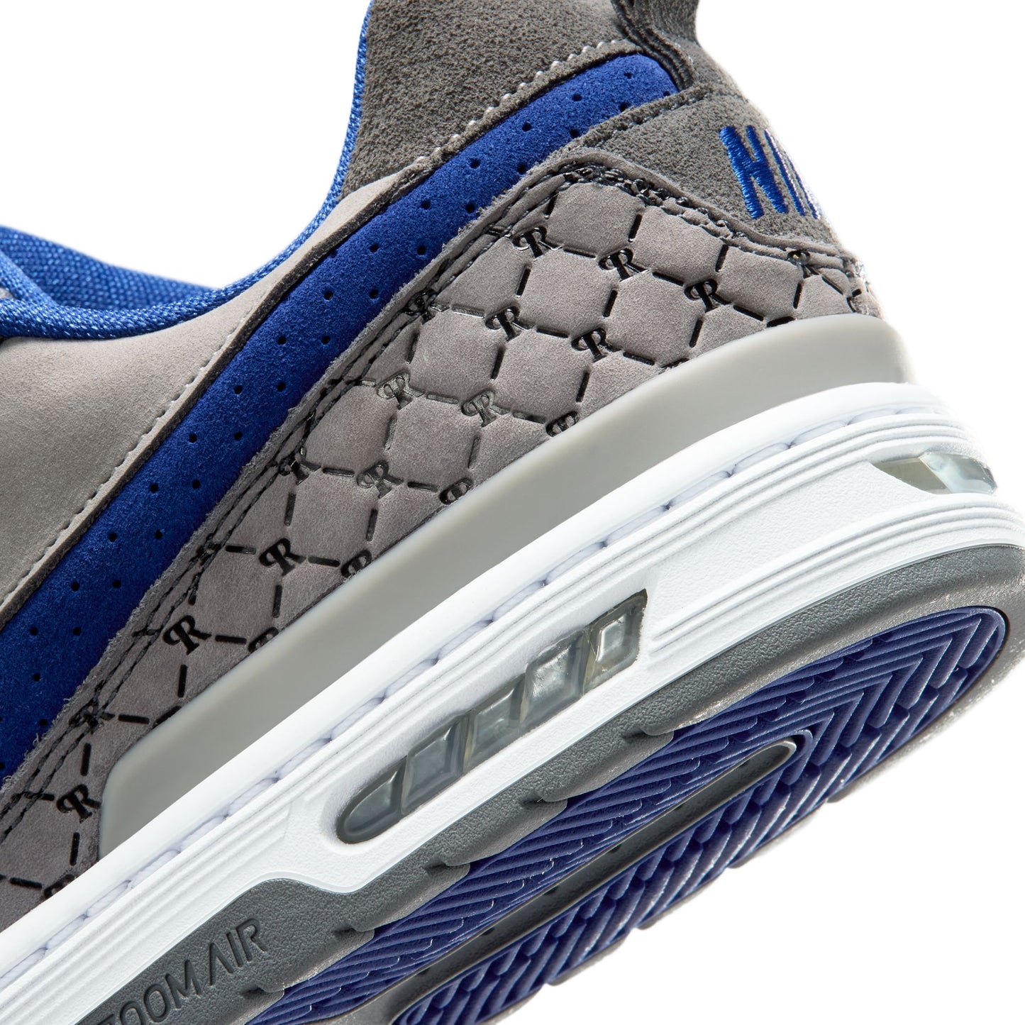 Close-up of a gray and blue sneaker with 'H' logo on a white background