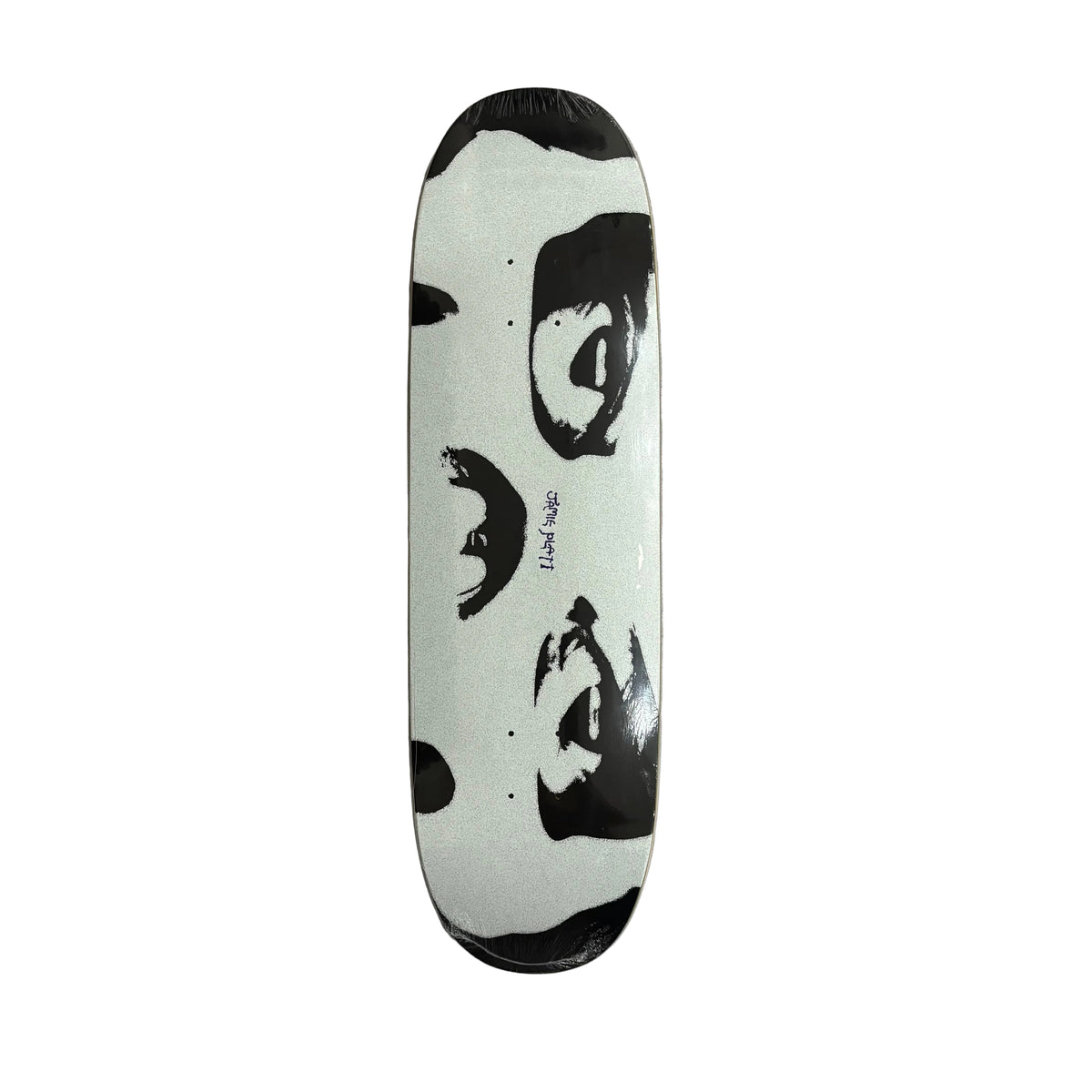 A skateboard deck with a black and white graphic print of a face, wrapped in protective plastic, lying on a white surface.