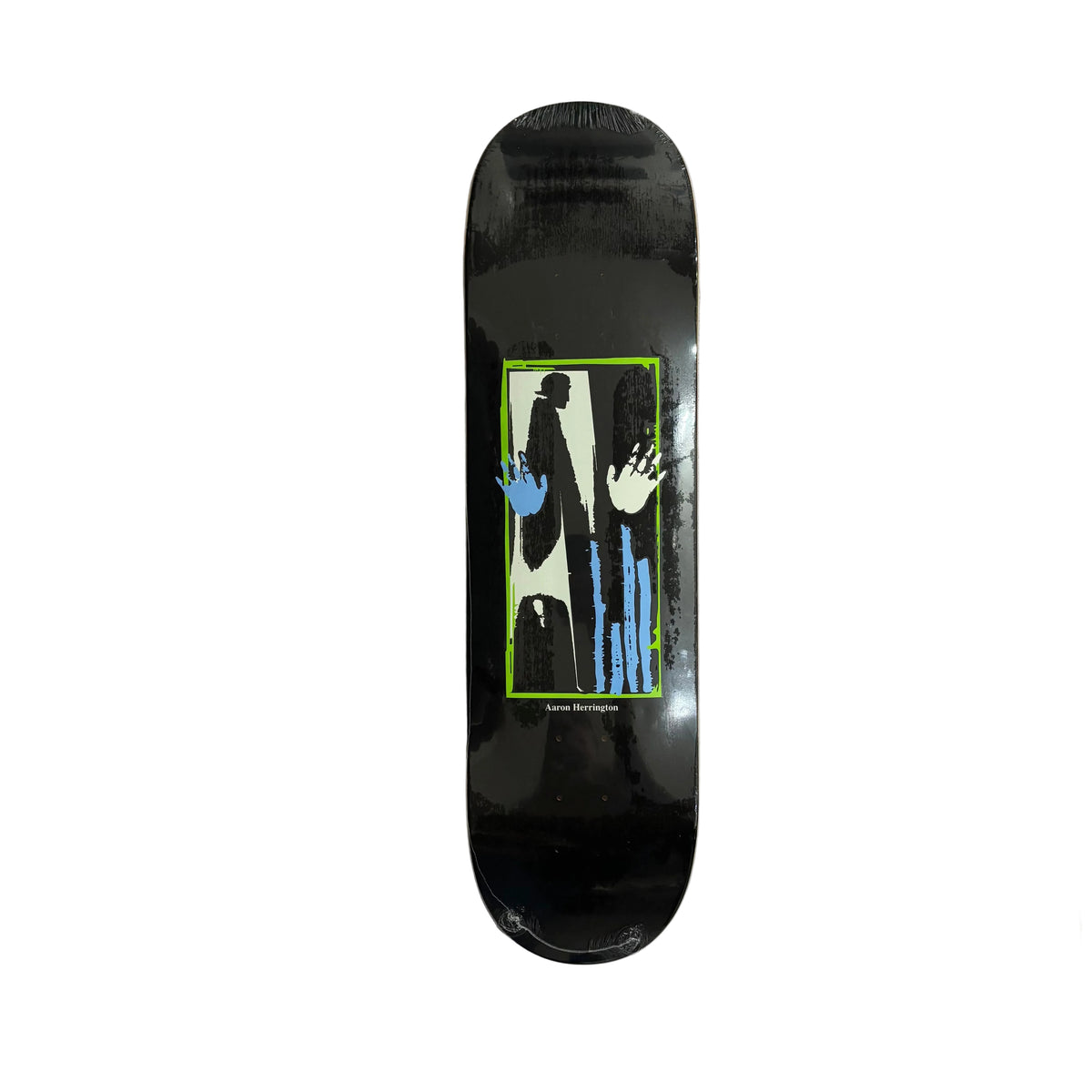 A black skateboard deck with a graphic print featuring a white silhouette, blue hands, and a bright green border, displayed on a white surface.