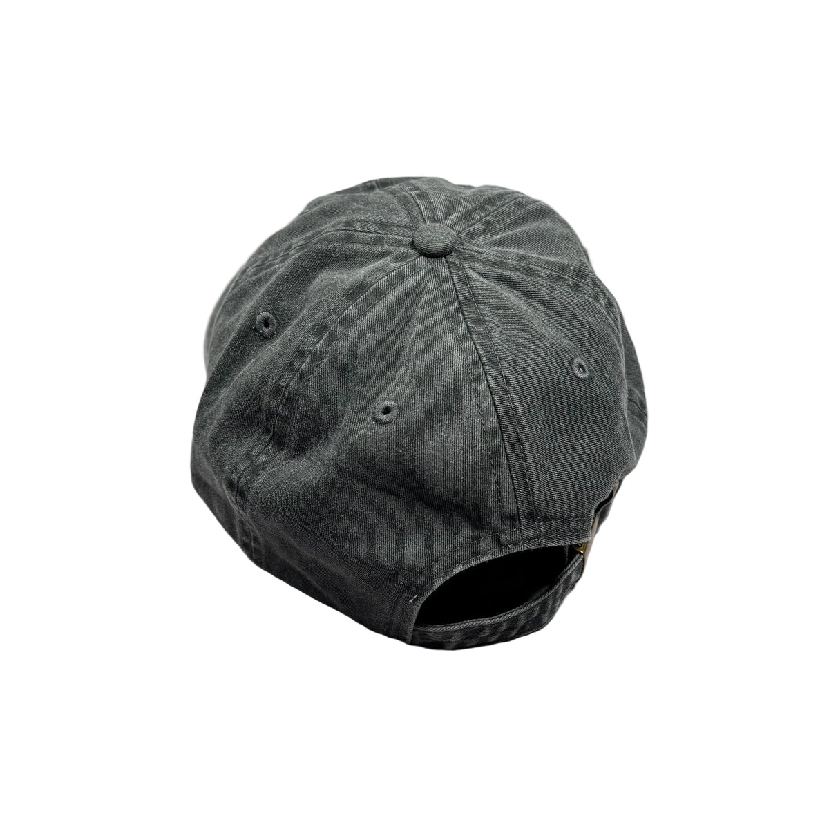 A dark gray washed baseball cap viewed from the back, resting on a textured light gray surface with a wooden floor visible in the top right corner.