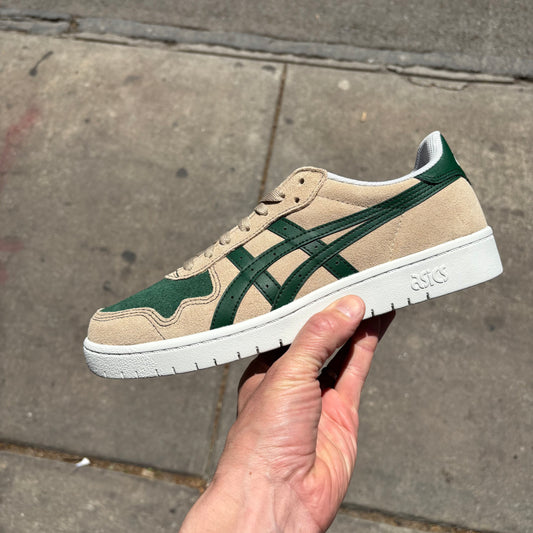 side view of cream colored suede skateboard shoe with green accents and white sole