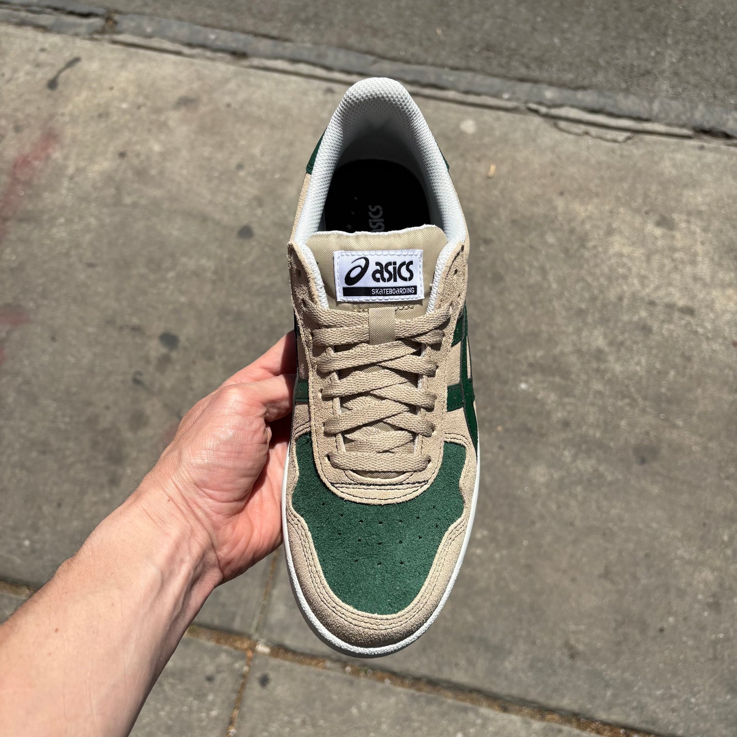 top down view of cream colored suede skateboard shoe with green accents and white sole