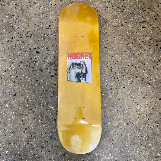 woodstained skateboard deck with a small square image of a man sticking his head into a tv