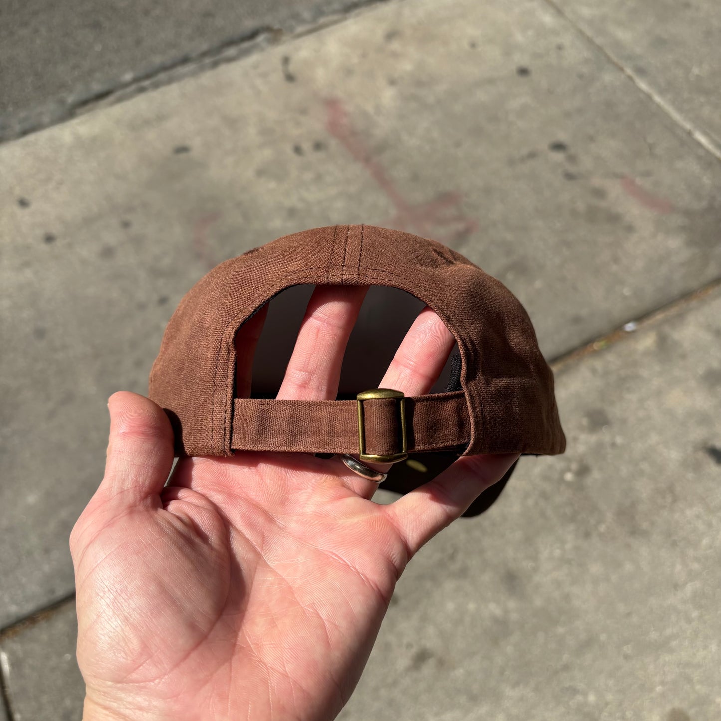 view of closure of brown waxed canvas cap
