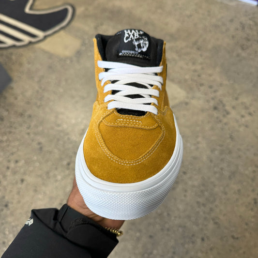 top down view of gold suede and canvas skateboard shoe, with laces visible, and black tounge