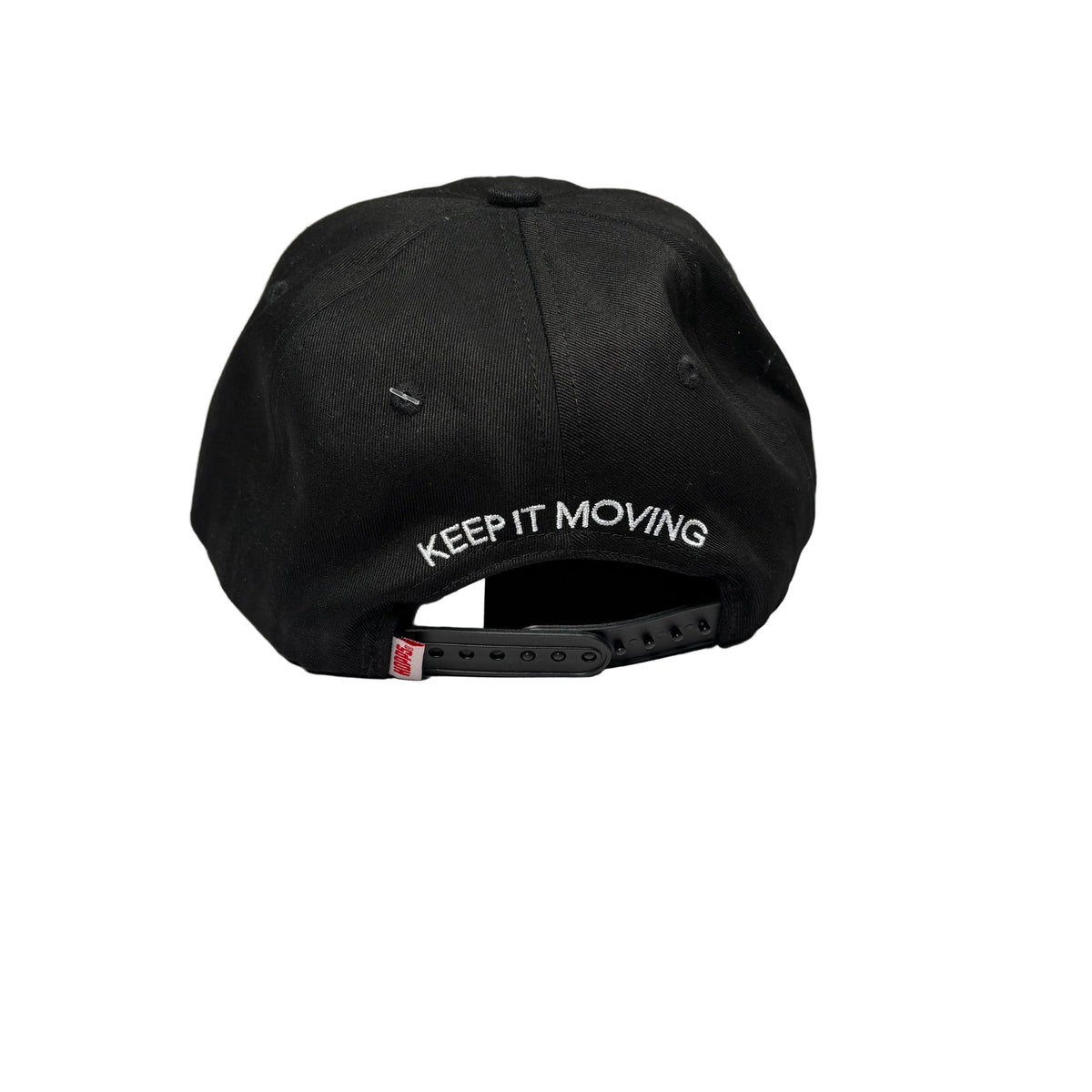 A black baseball cap with 'KEEP IT MOVING' embroidered in white on the back, resting on a white surface.
