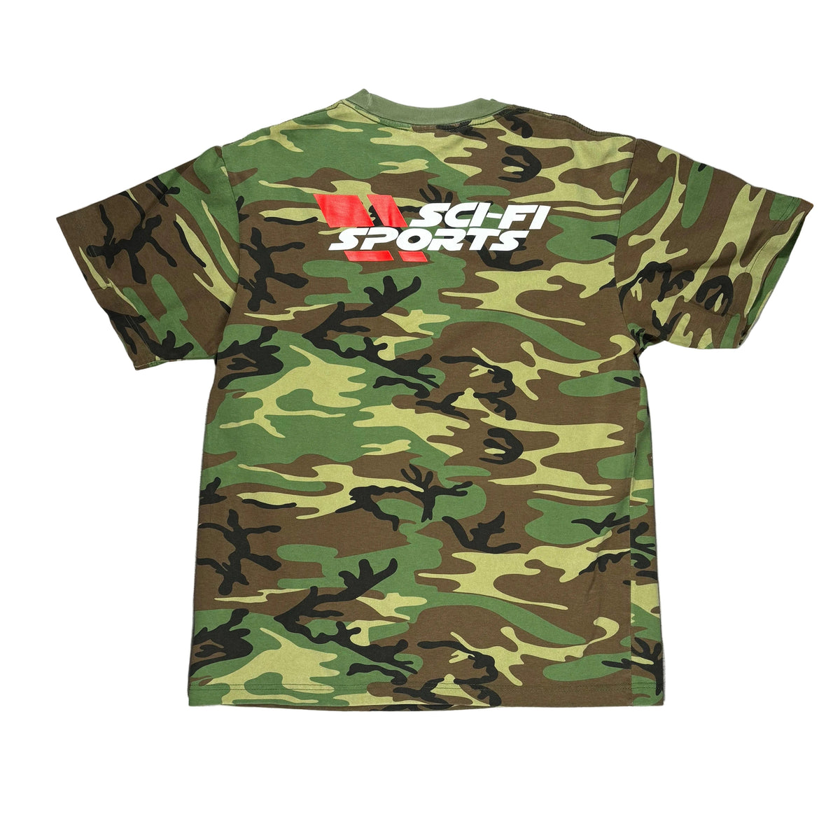 A camouflage-print short-sleeve shirt laid flat on a white surface with a green, brown, and black camo pattern and a white, red, and black 'SCI FI SPORTS' graphic near the upper back.