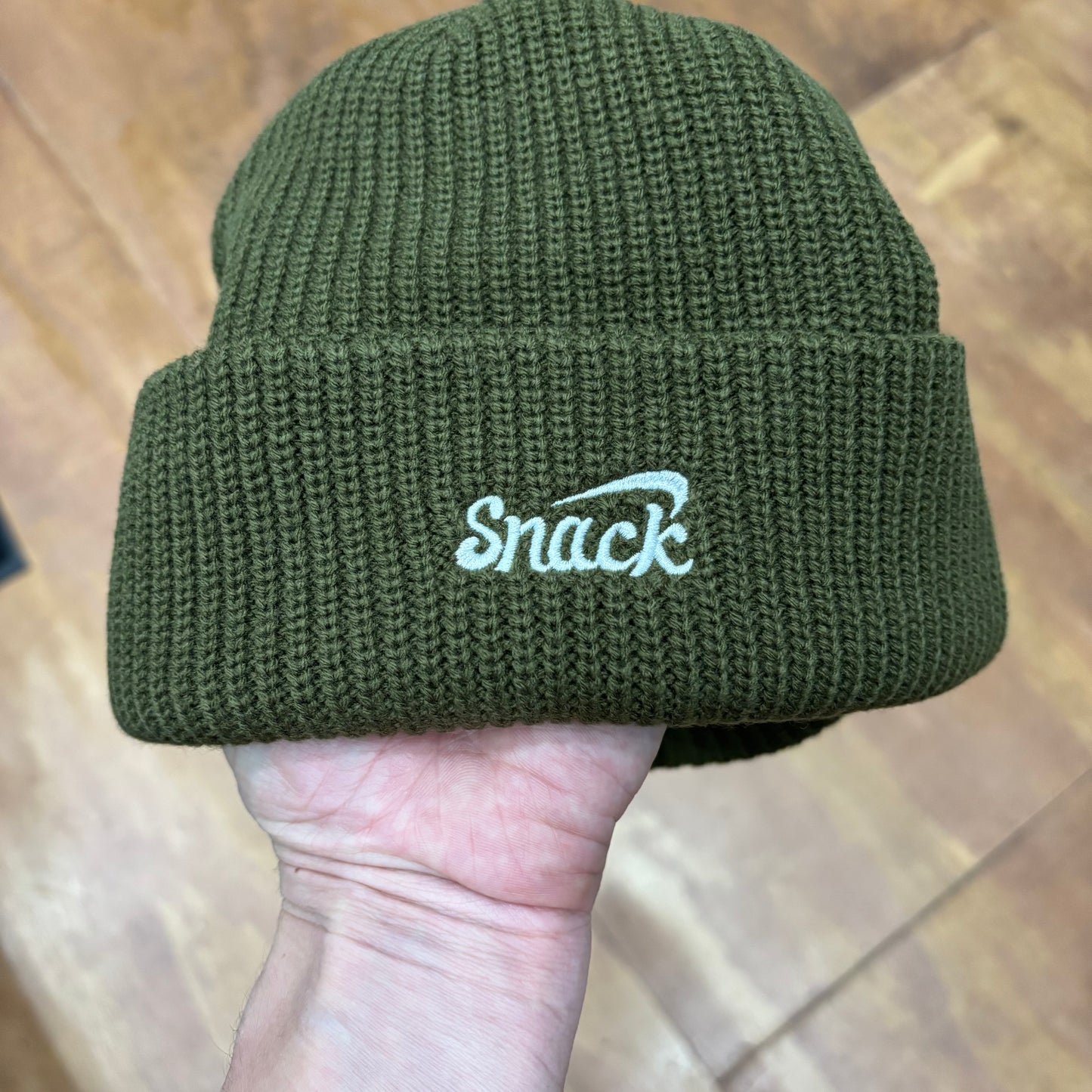view of rear of beanie with SNACK embroidery on it