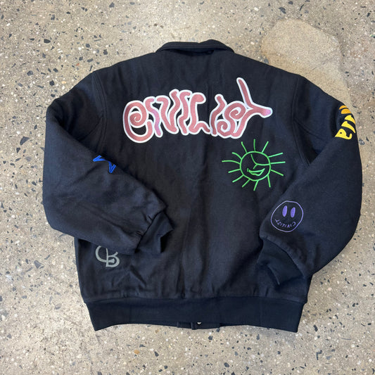Civilist logo, green sun, purple smiley face on back view of jacket