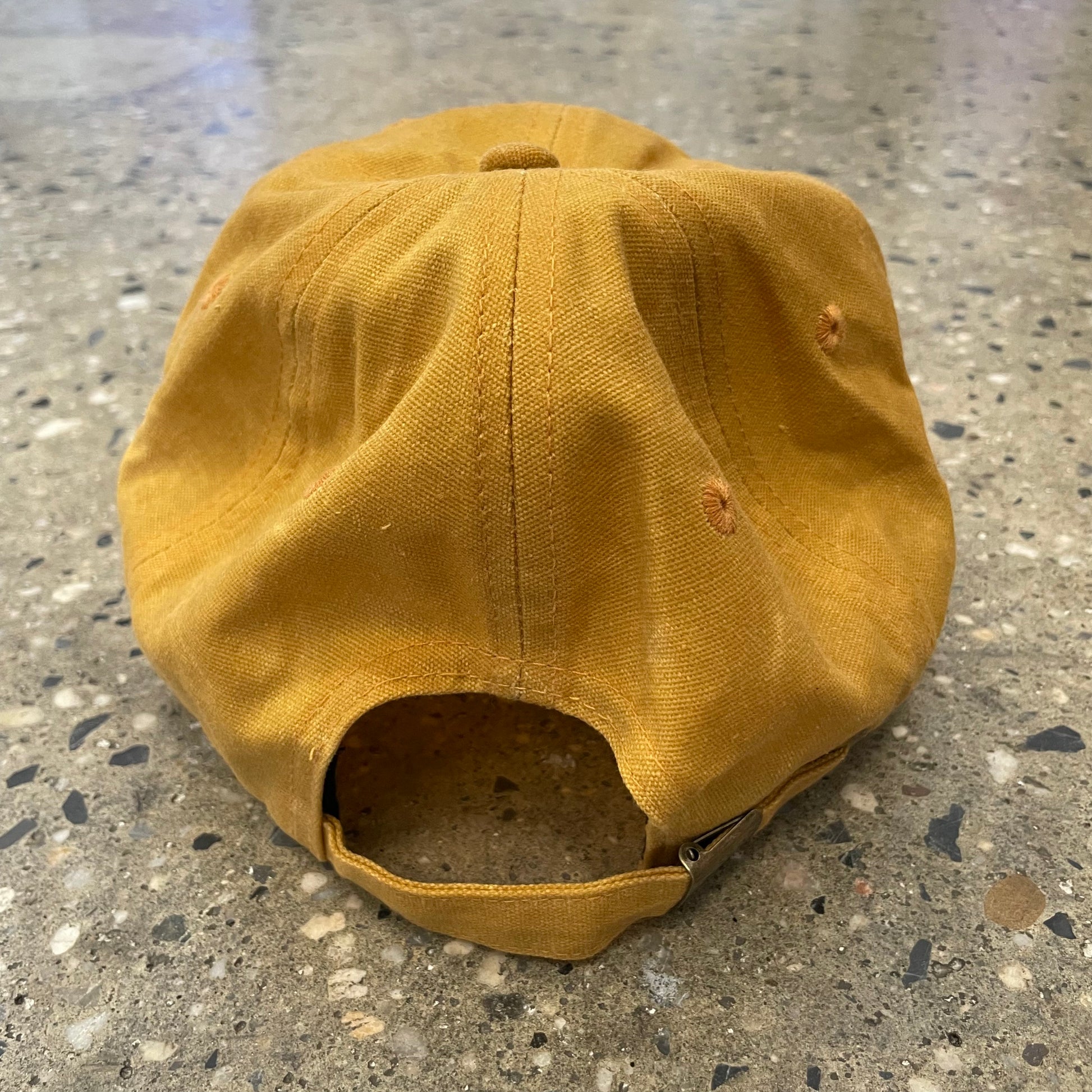 rear of gold waxed canvas six panel cap