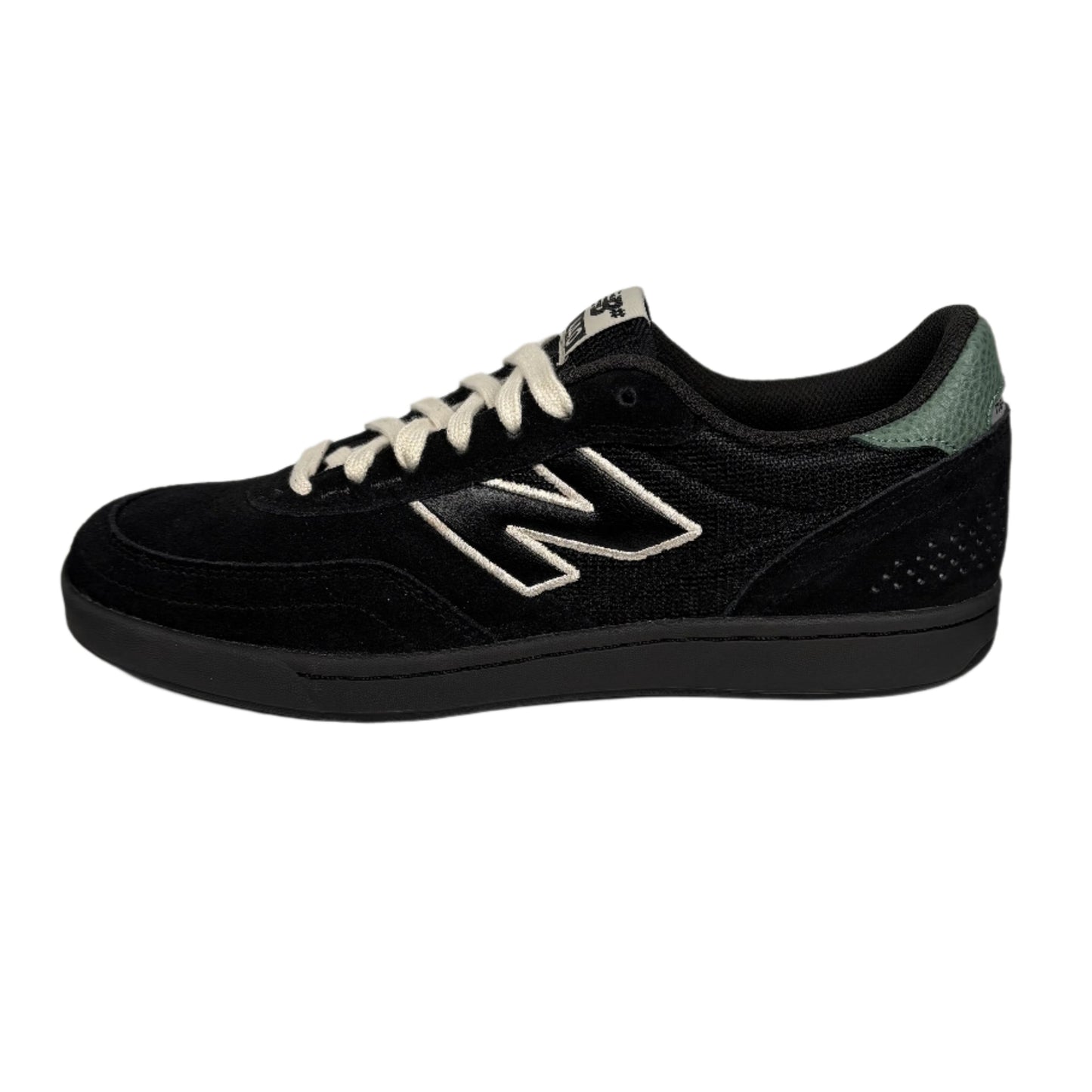 black suede lowtop new balance skate sneaker with white and green accents