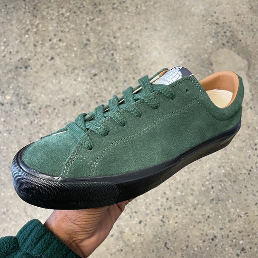 green suede sneaker with black sole, side view