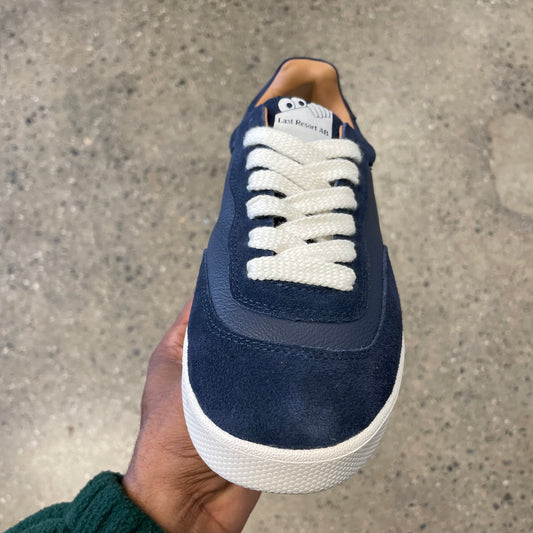 navy leather and suede sneaker with white sole, front view