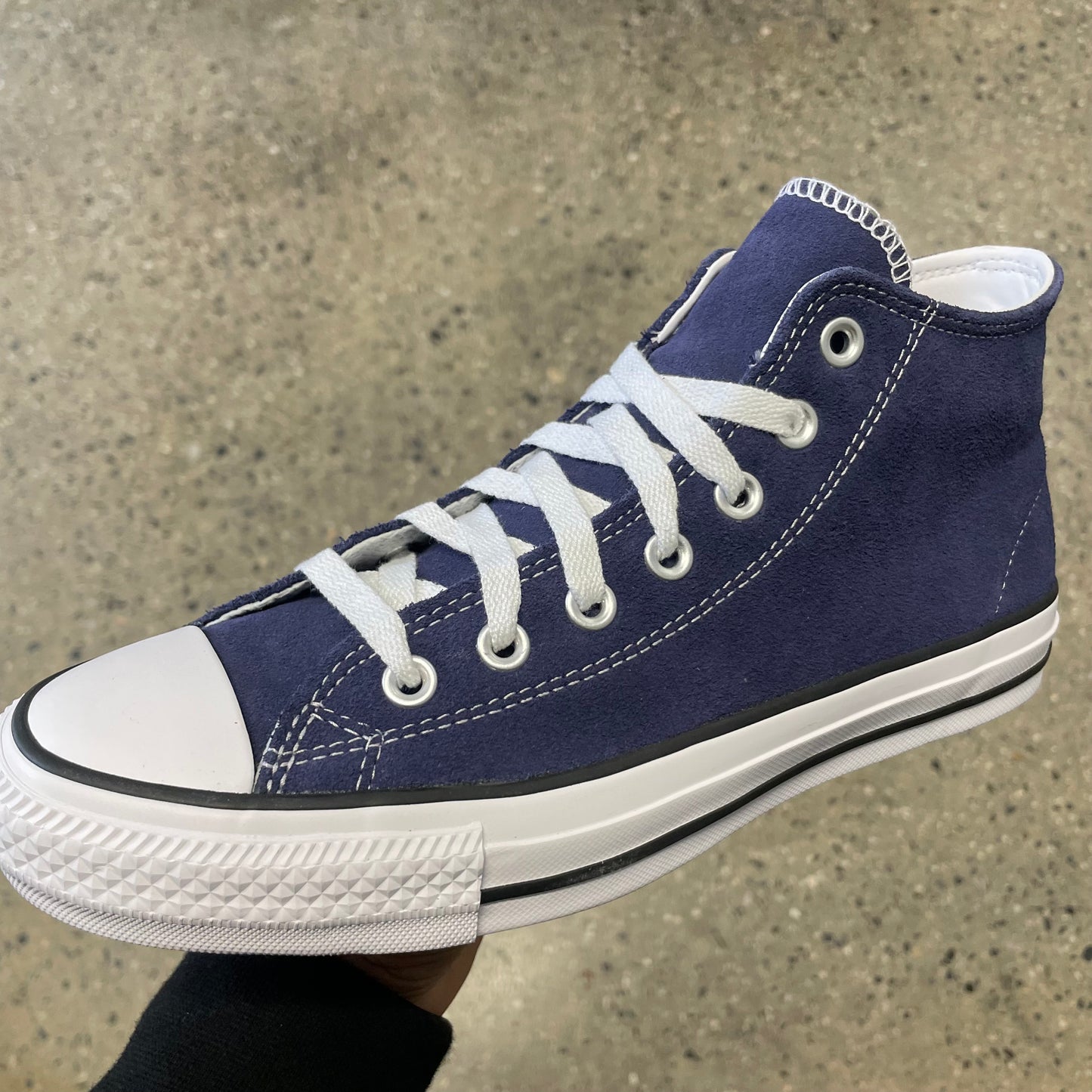 blue suede sneaker with white sole, toe, and stitch, side view