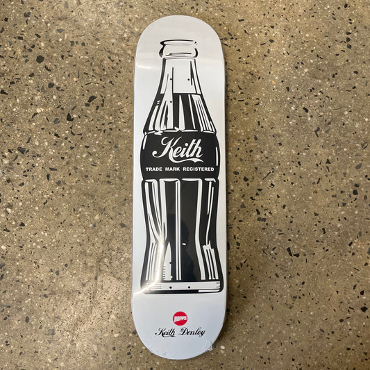 Black printed soda bottle that says 'keith' on white skate deck