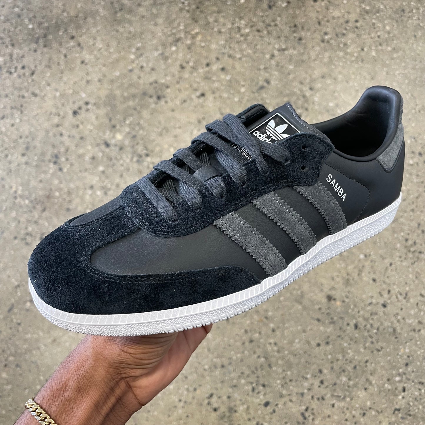 black leather and suede sneaker with grey stripes and white sole, side view