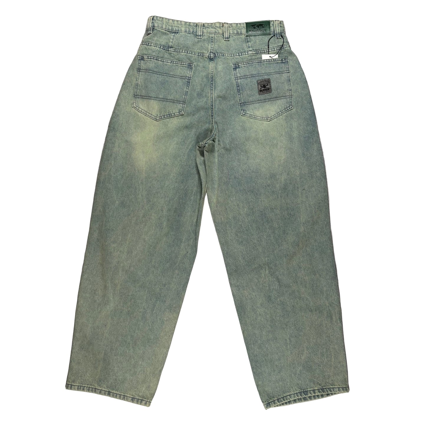 rear view of blue/Green jeans laid flat on a white surface
