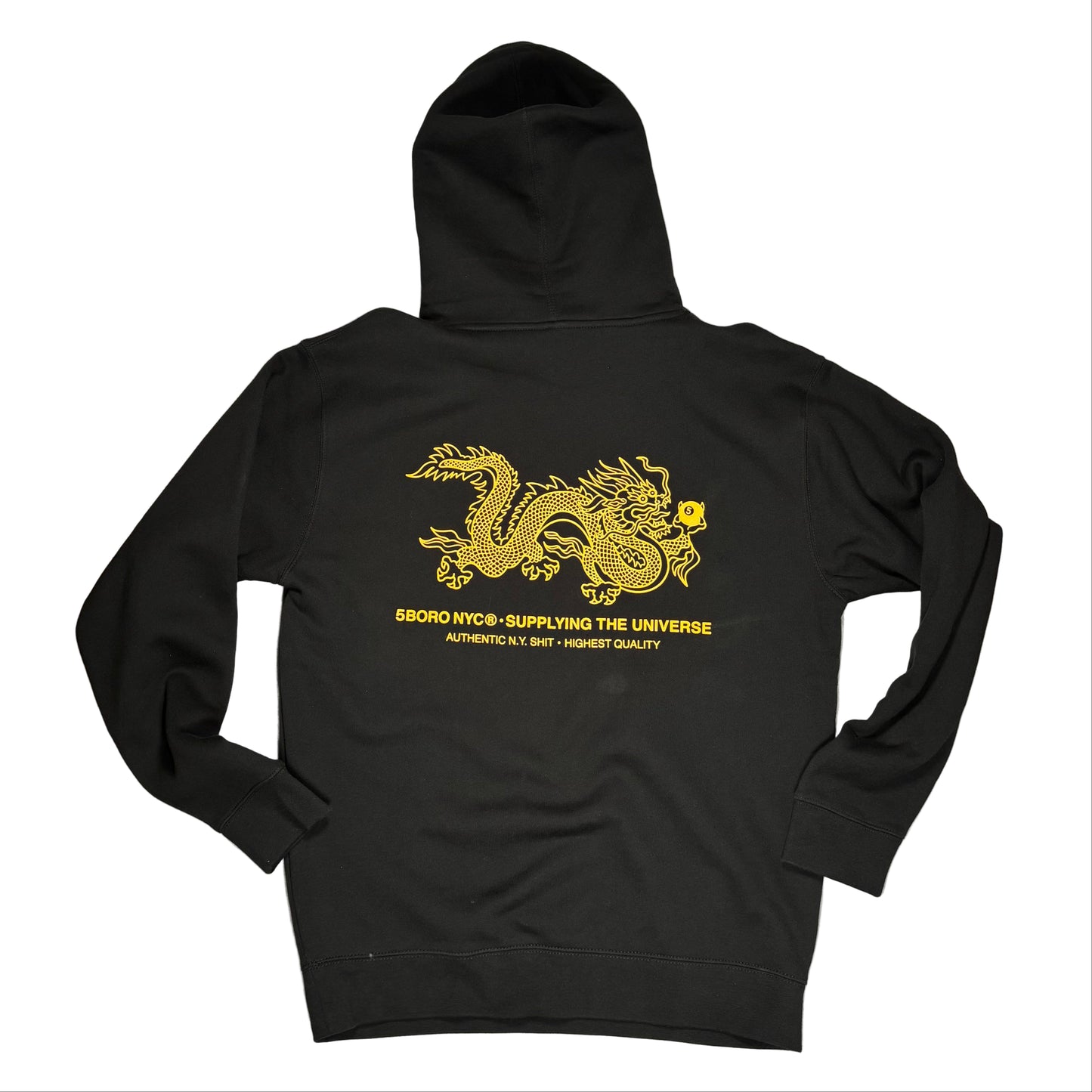 rear view of Black hoodie with gold dragon design on a gray surface