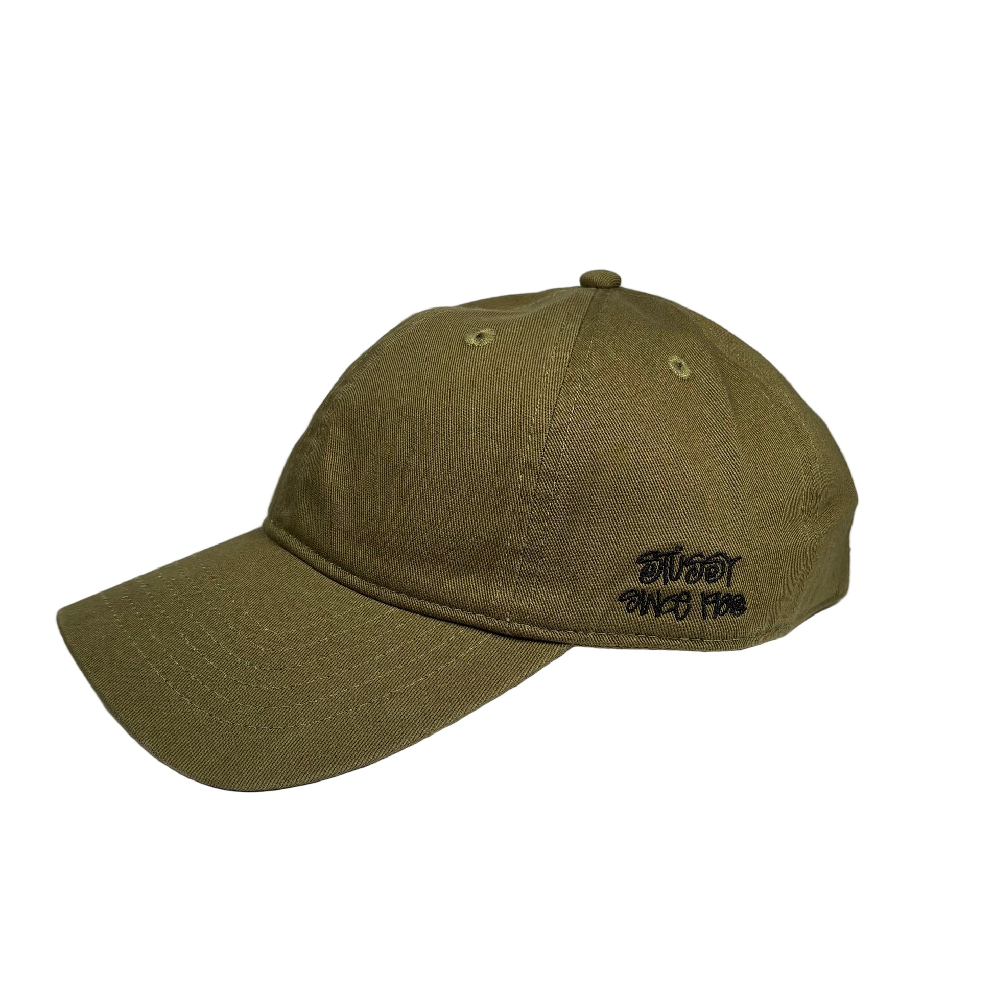 Green baseball cap with stussy text on a white background