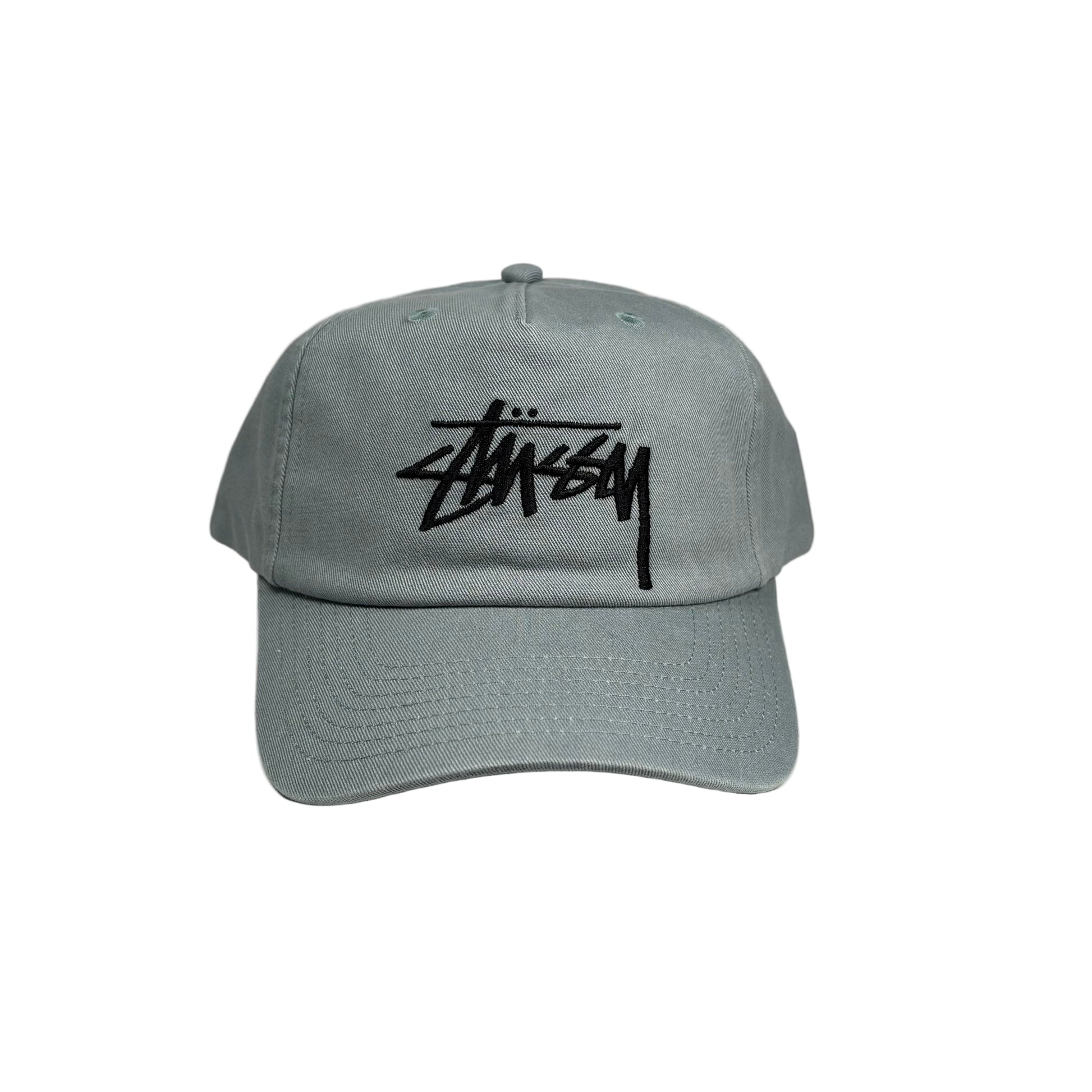 sea green cap with black stussy logo on a white  background