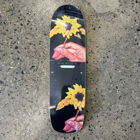 hand holding sunflower on black skate deck