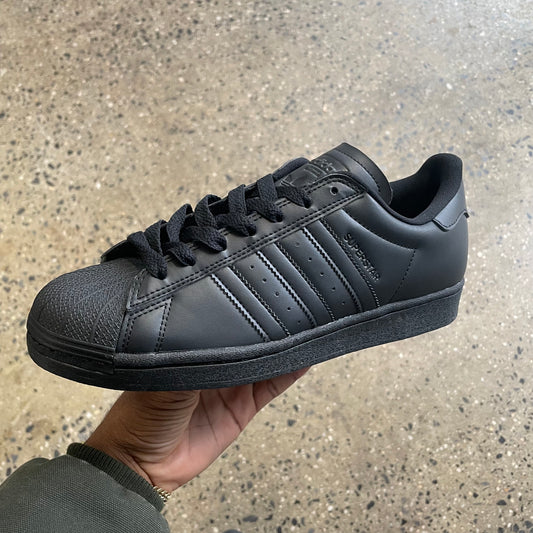 black leather sneaker with black sole, side view