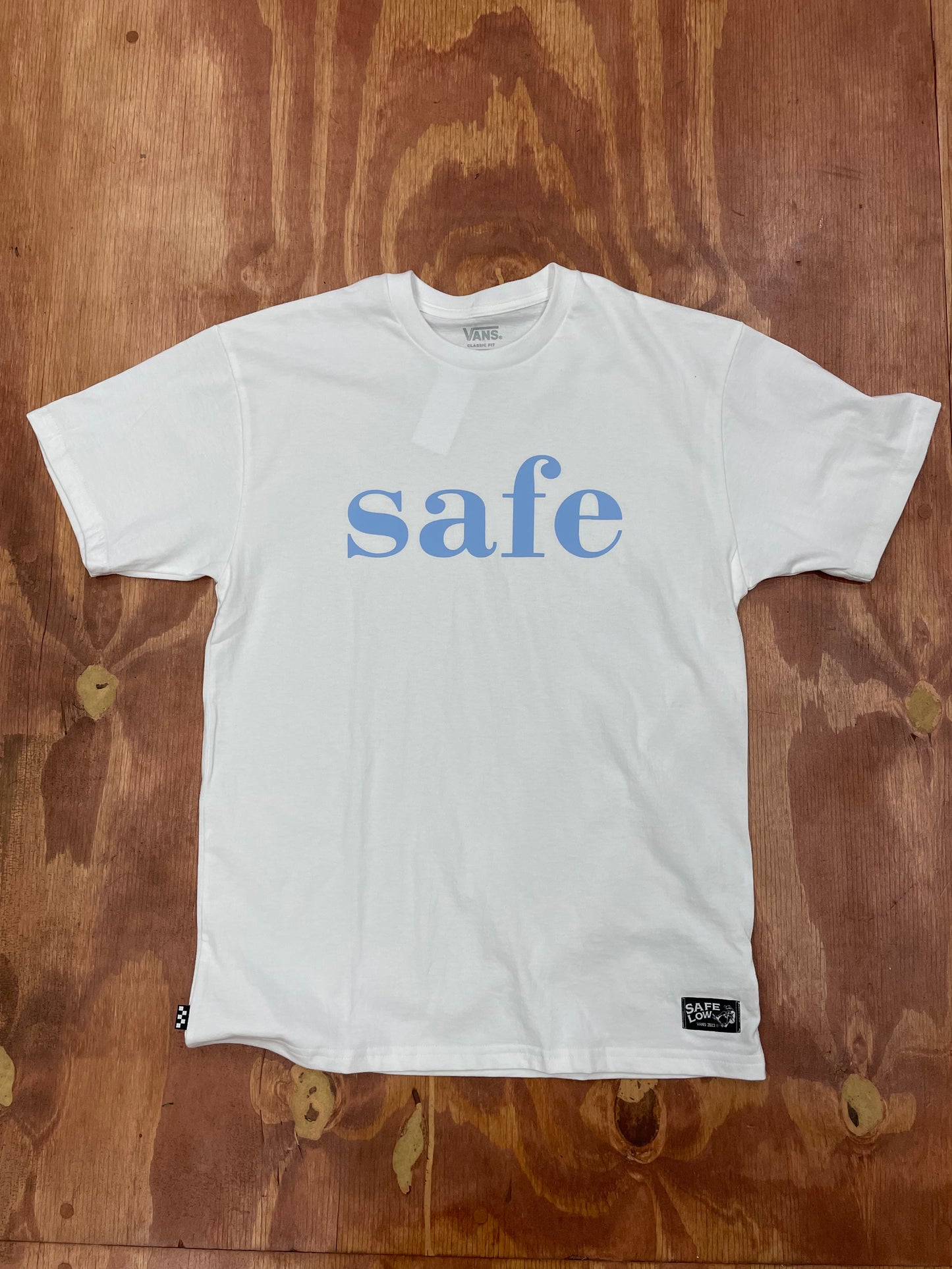 front view of SAFE logo in light blue on white t-shirt