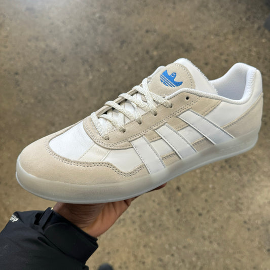 white leather and suede sneaker, blue logo, side view