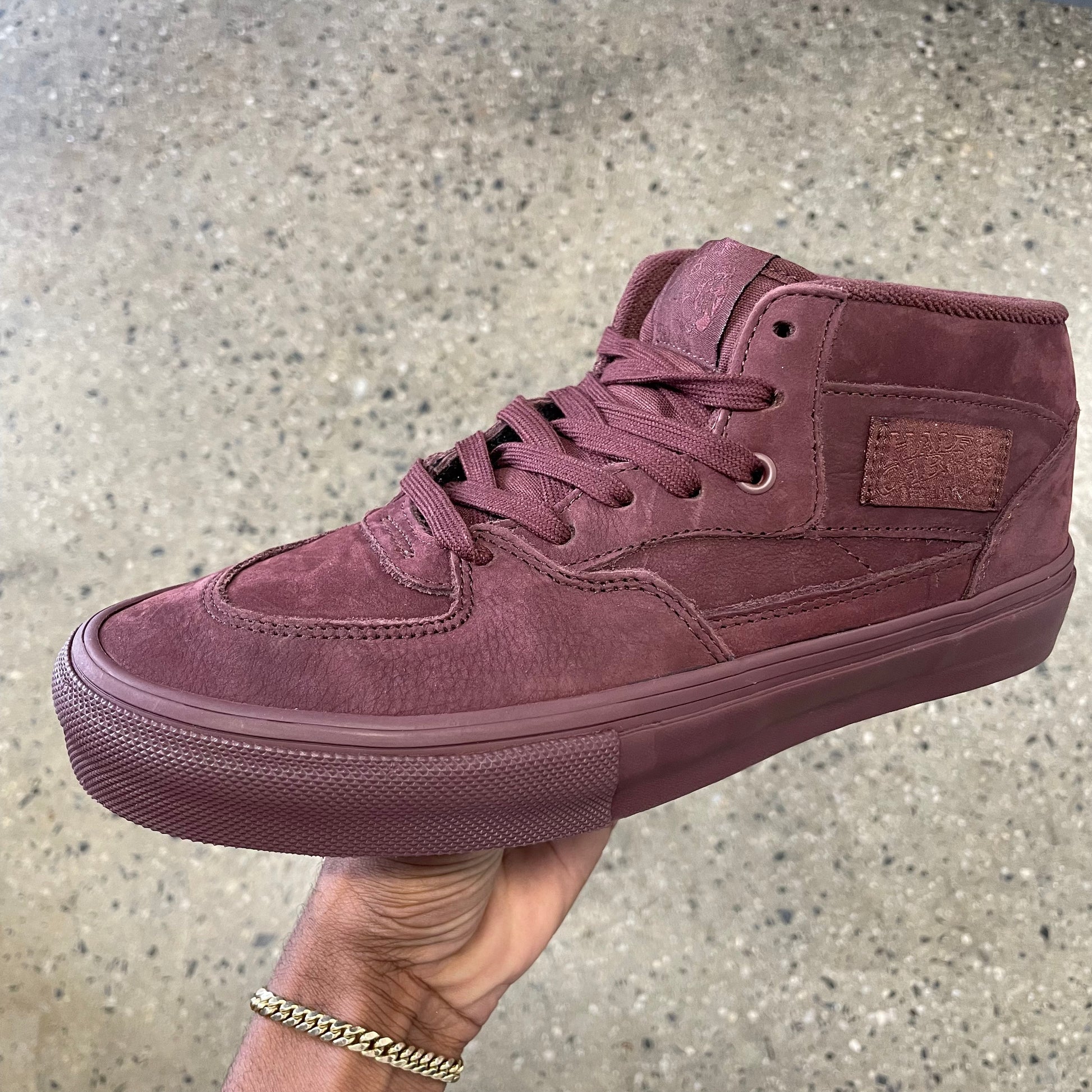 side view of premium suede mid top skateboard shoe in chocolate pig suede, looks closer to brick red in person