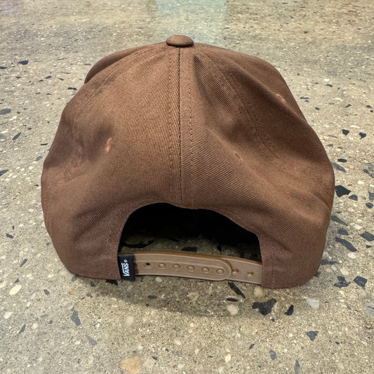 rear view of brown snapback cap, flag label