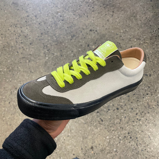 cream and olive sneaker with neon yellow laces and black sole, side view