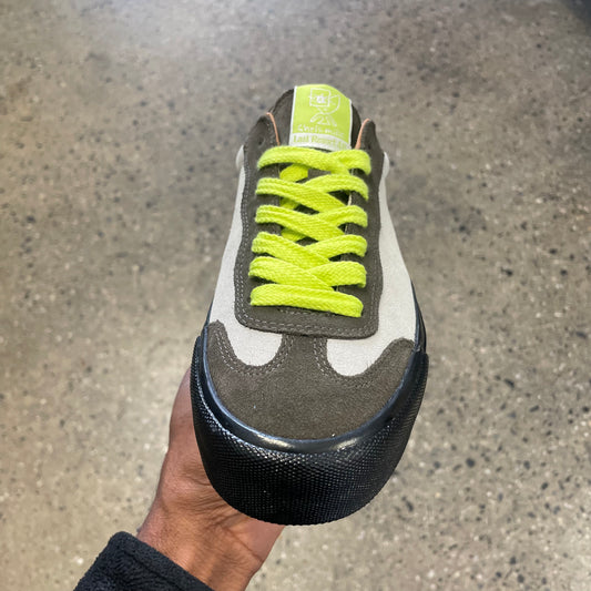 cream and olive sneaker with neon yellow laces and black sole, front view