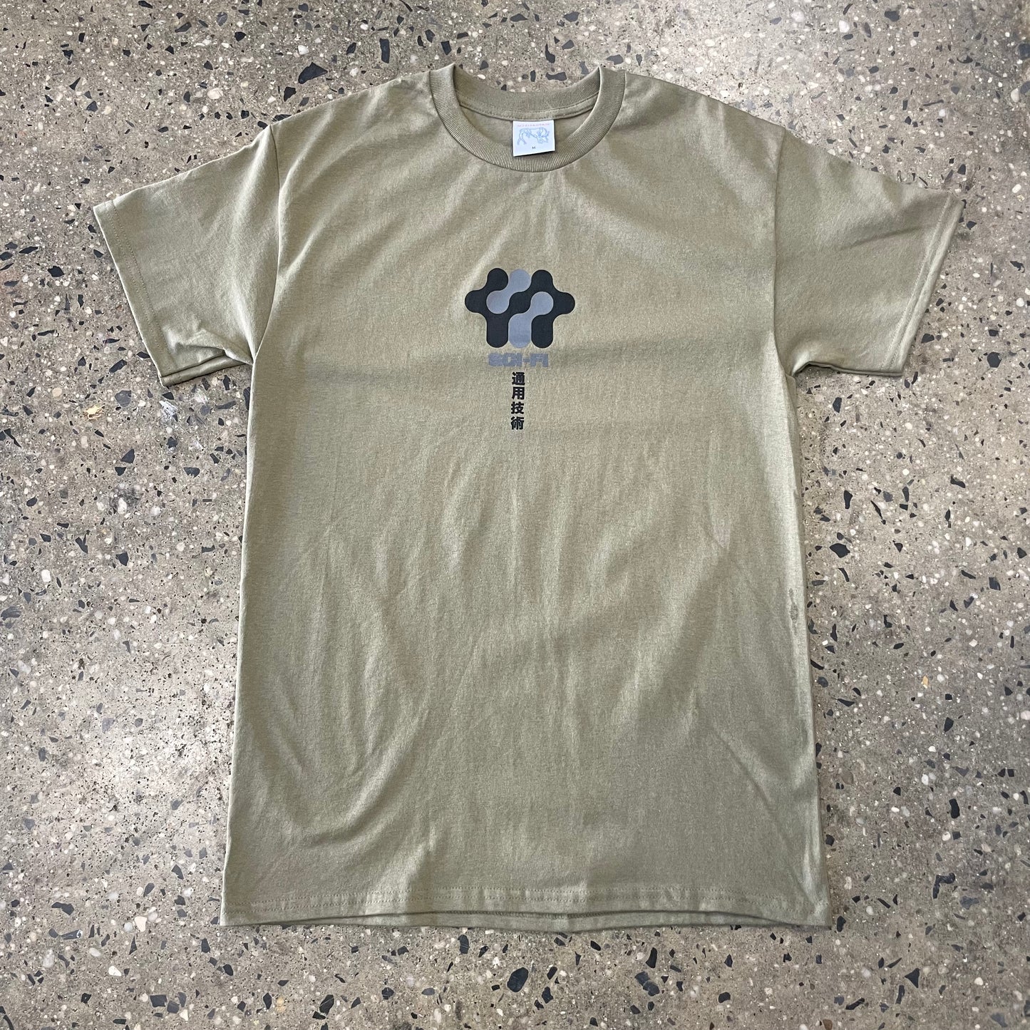 black and grey logo on light brown T-shirt