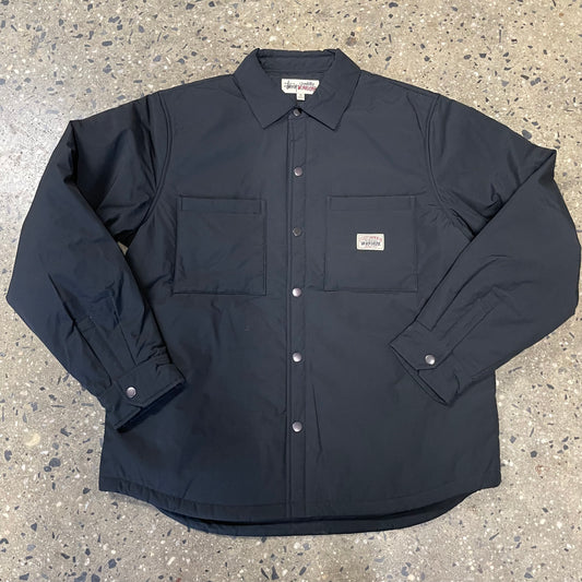 front view of snap closure black padded tech overshirt