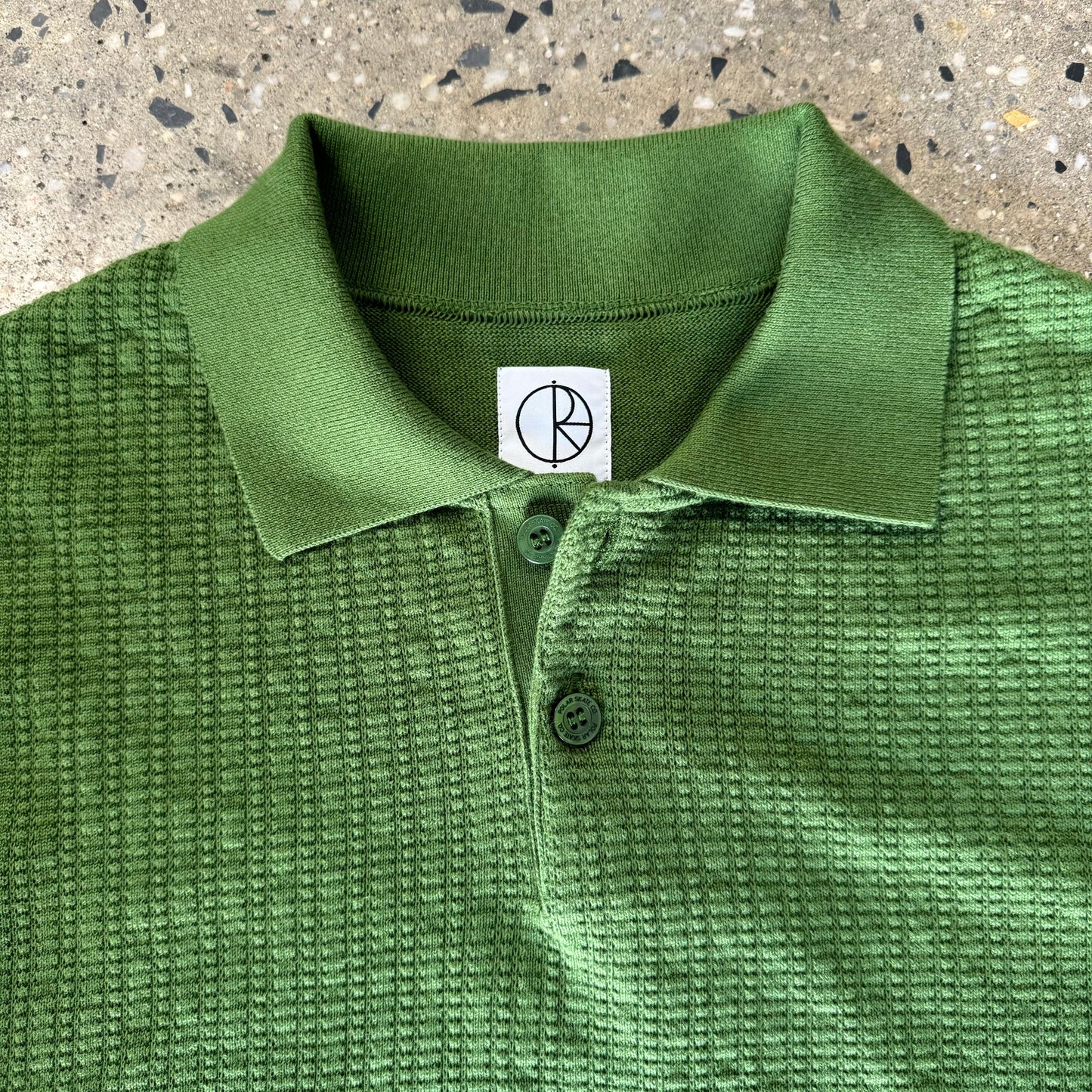 closeup of collar, knit, and green buttons