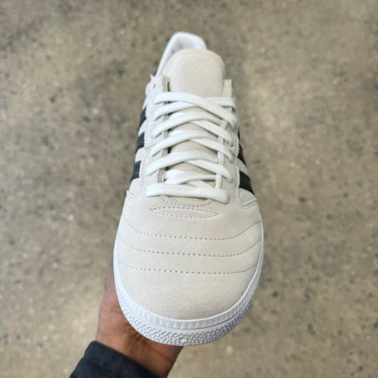white suede sneaker with black stripes and white sole, front view