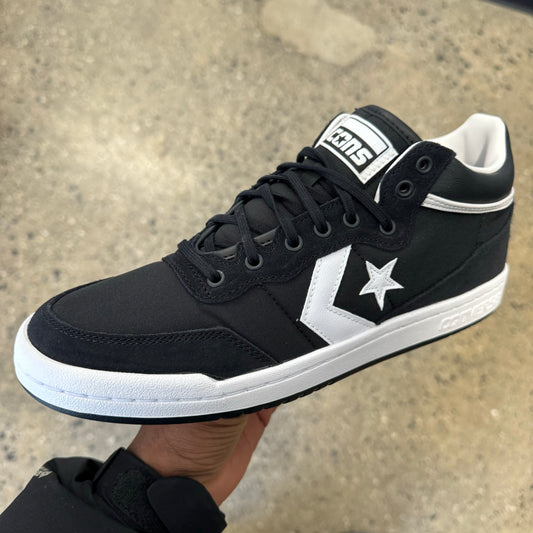 black sneaker with white strip, star and sole, side view