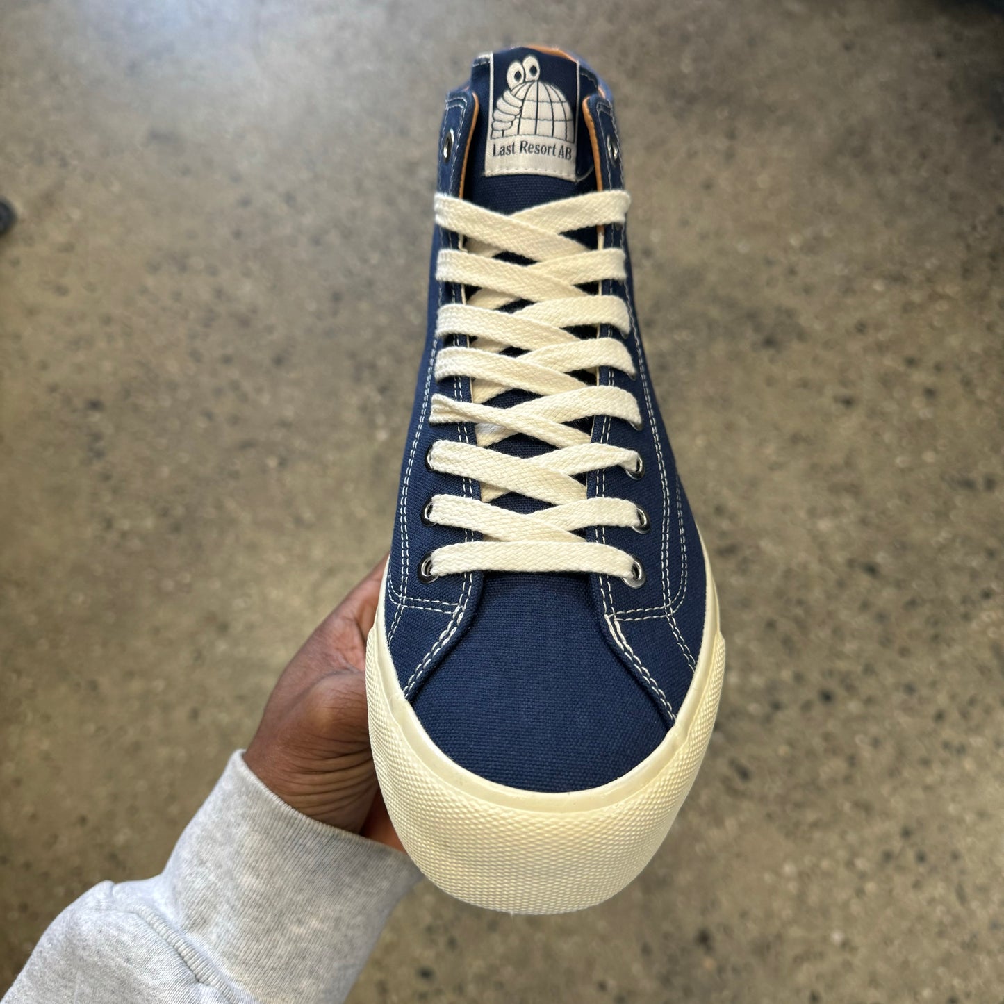 blue hi top sneaker with white sole and white stitch, top view