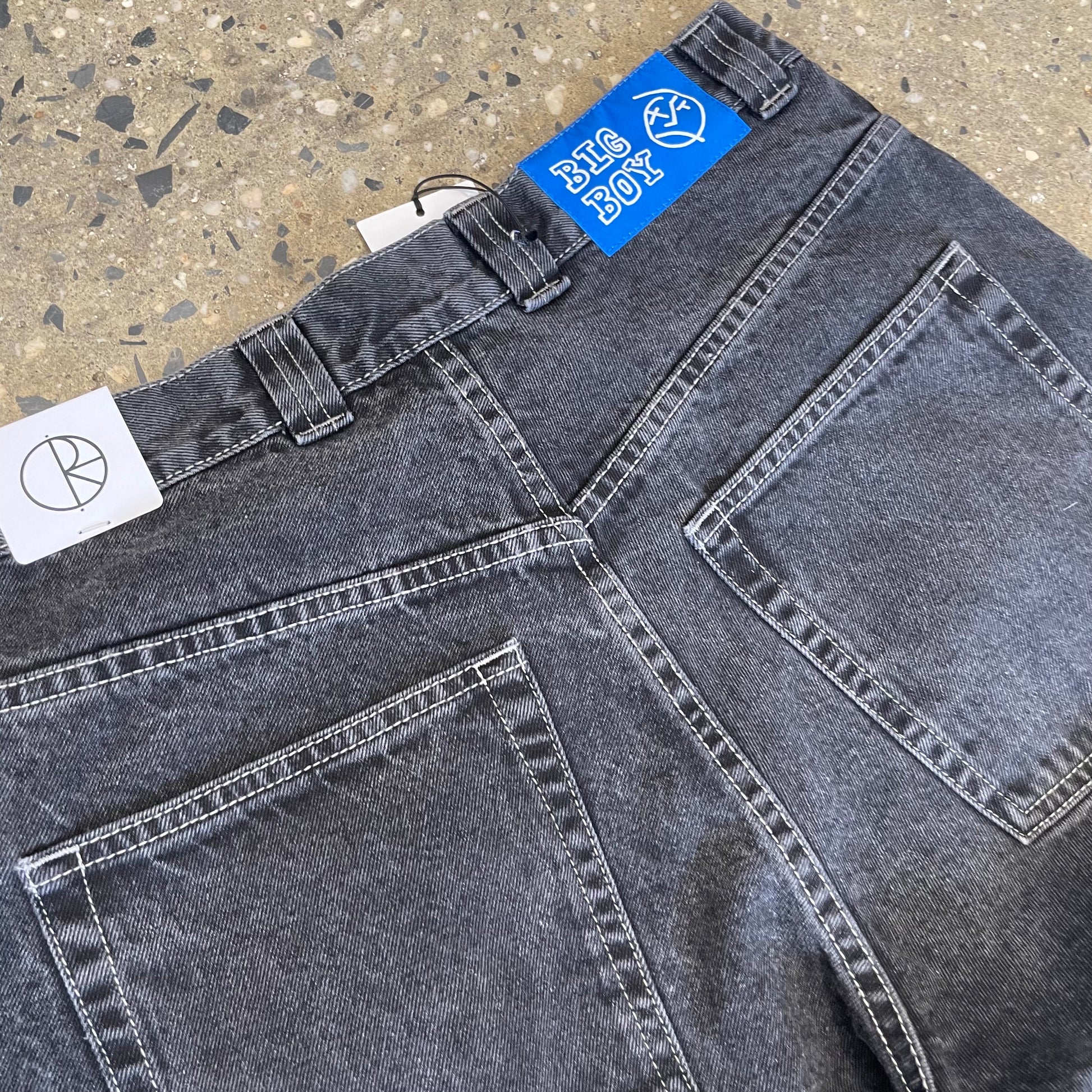 closeup of back pockets with blue patch logo on waistband