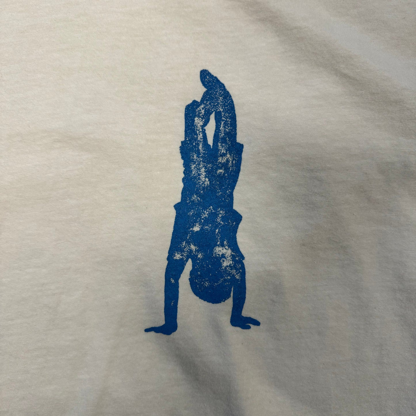 closeup of blue person doing a handstand on white T-shirt