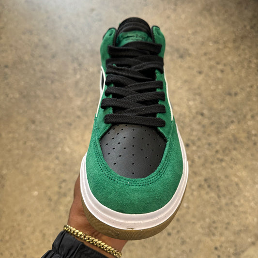 top down view of green and black suede and leather sneaker