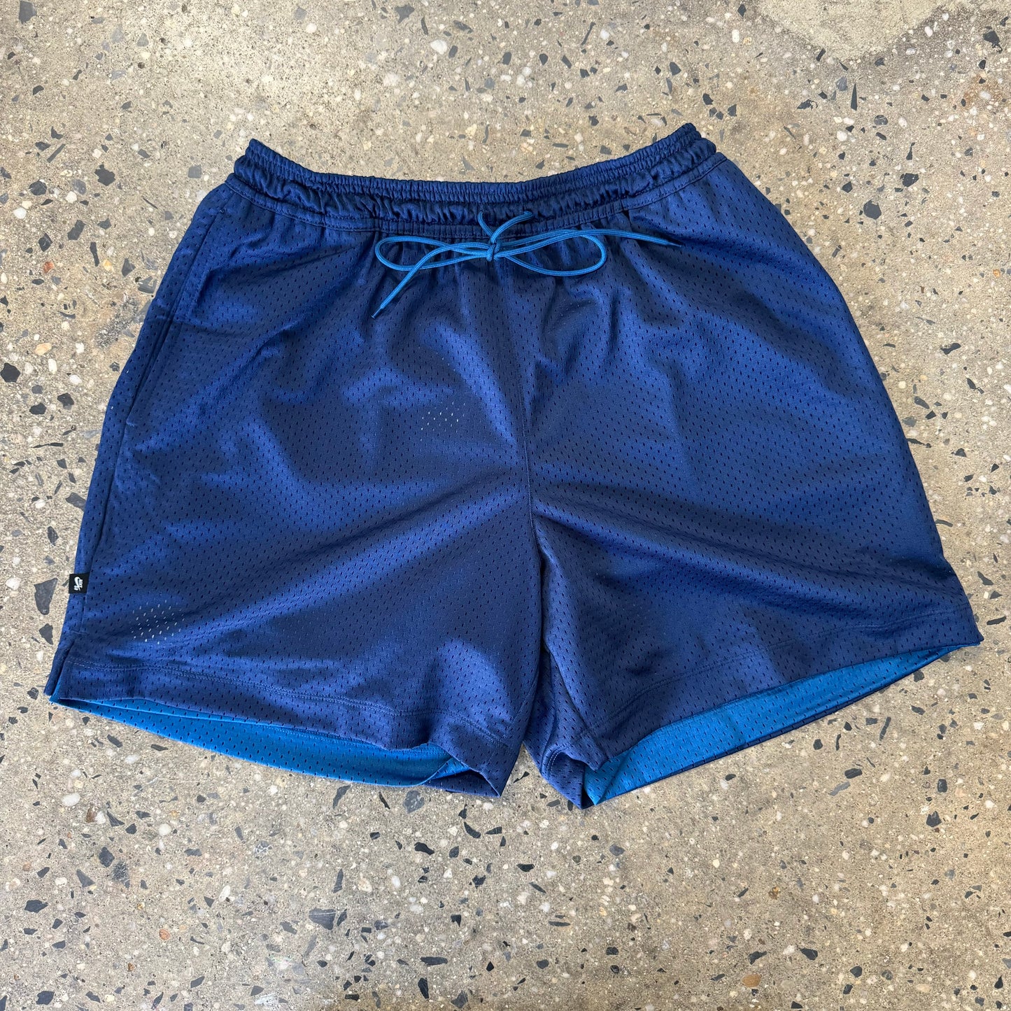 view of darker blue mesh shorts (reversed side)